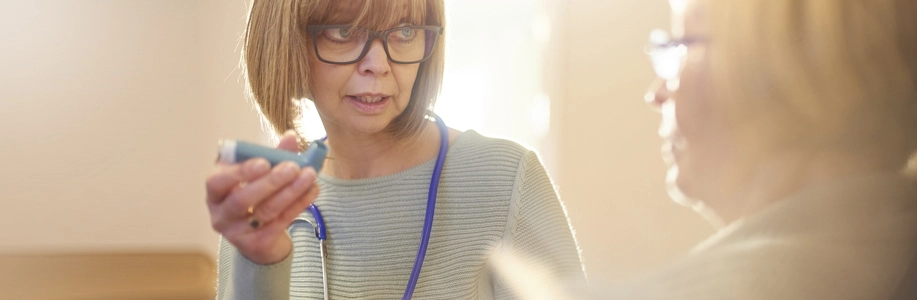 Health provider explaining inhaler to patient