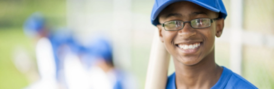 Teen boy holds baseball bat and smiles