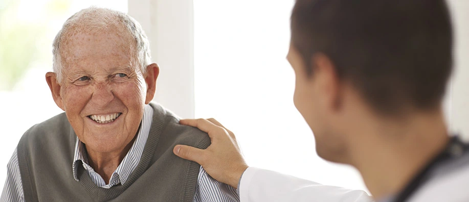Older man smiles with doctor