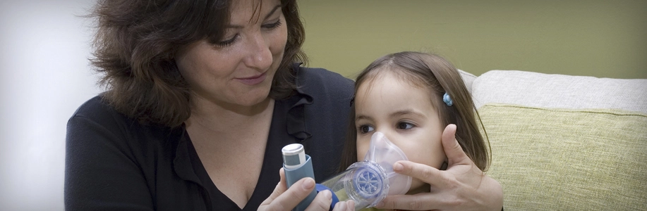 Mom helps young daughter with inhaler
